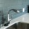 Close-up of kitchen faucet with teal backsplash at Eleanor Apartments in Seattle